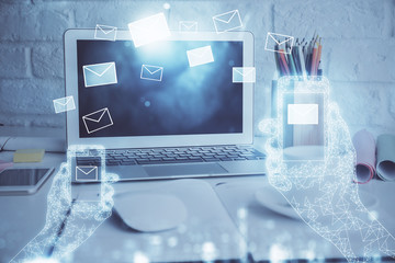 Desktop computer background in office and flying envelops hologram drawing. Double exposure. Electronic mail concept.