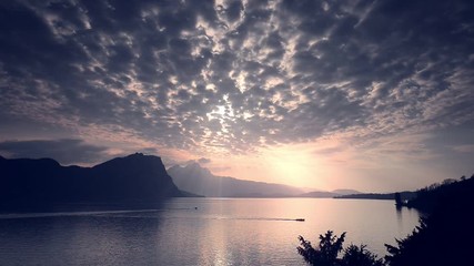 Wall Mural - The rays of the sun through the floating clouds. Gentle sunset over Lake Lucerne. Switzerland. 