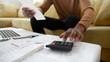 © fizkes - Black small business owner making calculations at home. Close up of african american man checking bills, counting expences, examining credit balance or planning household sitting on sofa in living