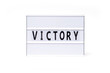 Victory. Text on a vintage lightbox display placed on a white table on a light background. 