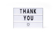 Thank You. Text on a vintage lightbox display placed on a white table on a light background. 