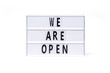  We are open. text on a vintage lightbox display placed on a white table on a light background.    