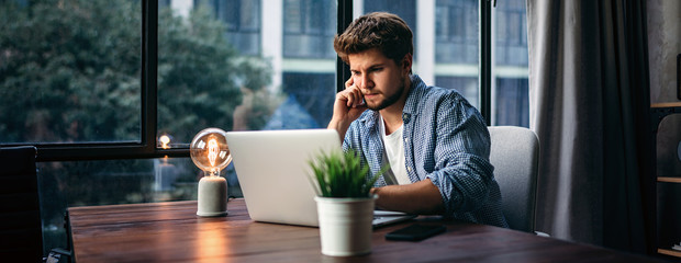 Young man working with a laptop. Freelancer connecting to internet via computer. Businessman at work