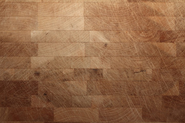 a close up of a used butcher's block with lots of knife marks and scratches