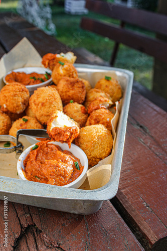 Cheese balls with tomato sauce. Fried snack starter meal. Party food © Irati