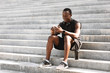 © Prostock-studio - Sporty black guy using smartphone after training outdoors, sitting on urban stairs