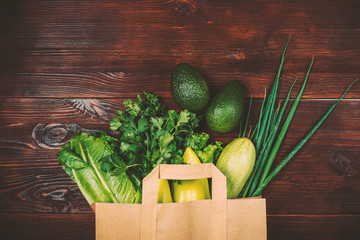 Wall Mural - Healthy food green vegetables and herbs in paper shopping bag