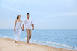 © New Africa - Happy couple having romantic walk on beach. Space for text