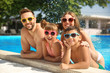 © New Africa - Happy family in swimming pool on sunny day