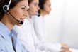 © rogerphoto - Call center. Group of operators at work. Focus on beautiful business woman in headset
