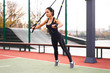 © Andrii - Girl athlete training using trx on sportground. Mixed race young adult woman do workout with suspension system. Healthy lifestyle. Stretching outdoors playground.