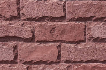 Wall Mural - Red stone wall background. The texture of the decorative stone. Close-up