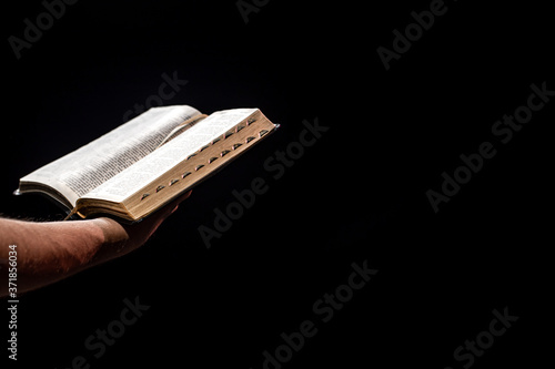 A man holds an open Bible. The concept of a relationship with God.