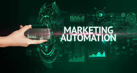 hand holding wireless peripheral with marketing automation inscription, modern technology concept
