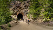 Biking into a tunnel of the abandoned Kettle Valley Railway carved in the rocks of Myra Canyon near Kelowna, British Columbia, Canada 