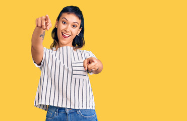 Young woman wearing casual clothes pointing to you and the camera with fingers, smiling positive and cheerful