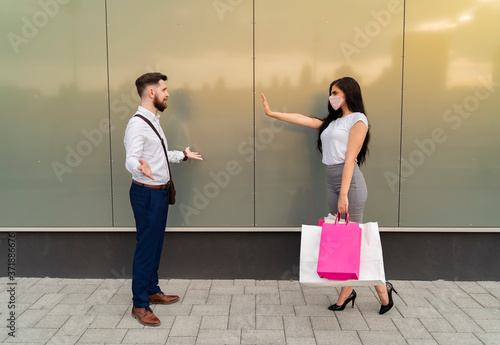 Fotomural Young woman doesnt allow man to approach her without face mask