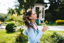 Young Woman In A Sporting Suit Drinks From A Bottle After A Workout