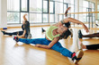 © DragonImages - Flexible beautiful young woman doing splits and bending to her leg to warm up before intense training
