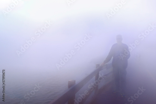 brain fog man standing on bridge in the fog