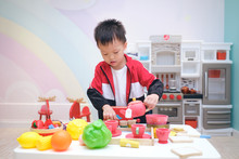 Cute Little Asian 3 -4 Years Old Toddler Boy Child Having Fun Playing Alone With Cooking Toys, Kitchen Set, Pretend And Role Play Toys For Young Kid Concept