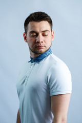 Wall Mural - Portrait of a man in a white polo on a white background. Male image for every day. Stylish guy