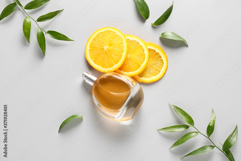 Bottle of citrus perfume on light background