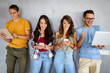 © NDABCREATIVITY - Education, technology and people concept. Happy group of friends using digital devices