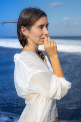 Wall Mural - Close up portrait of beautiful woman with jewelry. Caucasian woman enjoying sunlight and looking to the ocean. Beauty and fashion concept.