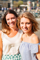 Two women posing for camera hugging each other