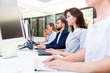 © JackF - Side view of row of ordinary business people working with computers in modern open plan office