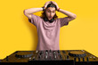 © Roman - dj man shocked after seeing vinyl turntable equipment, going to perform music on it, hold hands on head, surprised. isolated yellow background