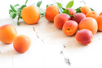 Wall Mural - Fresh sweet apricots on the white rustic table closeup. Healthy sweet fruits, harvest time.