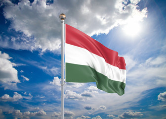 Wall Mural - Realistic flag. 3D illustration. Colored waving flag of Hungary on sunny blue sky background.