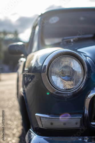 Close-up of a round headlight on an old car. On against the sun © Анатолий Савицкий