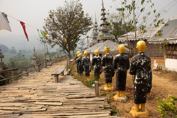 Buddha statue with Su Tong Pae bamboo bridge for foreign travelers thai people travel visit and respect praying in Phu Sa Ma temple of Ban Kung Mai Sak village at Pai city in Mae Hong Son, Thailand