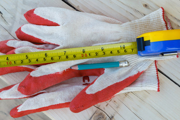 Work gloves, measuring tape and pencil. View from above.