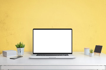 Wall Mural - laptop computer mockup on office desk with yellow wall in background. isolated screen in white for w