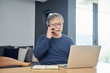 © west_photo - 部屋の中でスマートウォンを使用するシニアの男性