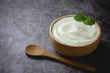 Plain Yogurt in wooden bowl on table
