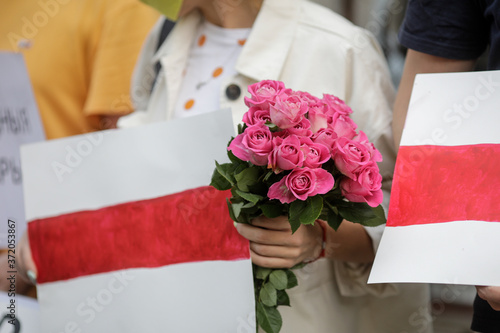 Details with people holding banners and flowers during a political rally supporting the protests in Belarus.