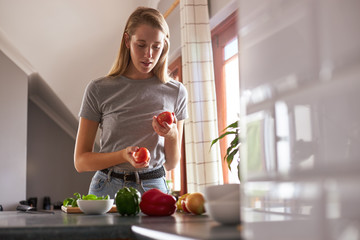 Wall Mural - Woman preparing vegetarian dinner in a kitchen