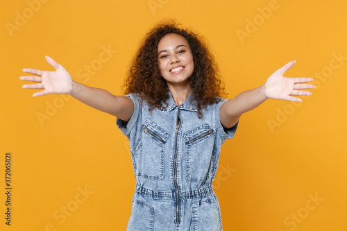 Fotomural Smiling young african american woman girl in casual denim clothes isolated on yellow background studio portrait