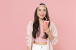 Smiling young asian woman girl in casual clothes cap posing isolated on pastel pink background studio portrait. People sincere emotions lifestyle concept. Mock up copy space. Hold cup of cola or soda.