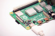 © PeterPike - Kiev, Ukraine - August 13th, 2020: Connected to power supply by USB 3.0 type C cord SBC budget micro computer Raspberry Pi 4B. Isolated photo of RPI4B on white background.