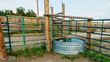 Stock tank and metal fence panels and wooden fencing in the animal corral on a working ranch near Denver