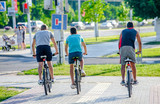 Fototapeta  - Cyclists ride on the bike path in the city Park
