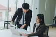 © Nawarit - Asian male and female colleagues are discussing  work with graph paper and a notebook.