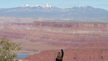 Slow Motion Shot Of Female Tourist Making Peace Sign In Front Of View From Dead Horse Point State Park In Utah, USA