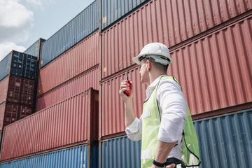 Wall Mural - Container Logistics Shipping Management of Transportation Industry, Transport Engineer Managing Control Via Walkie Talkie in Containers Shipyard. Business Cargo Ship Import/Export Factory Logistic.